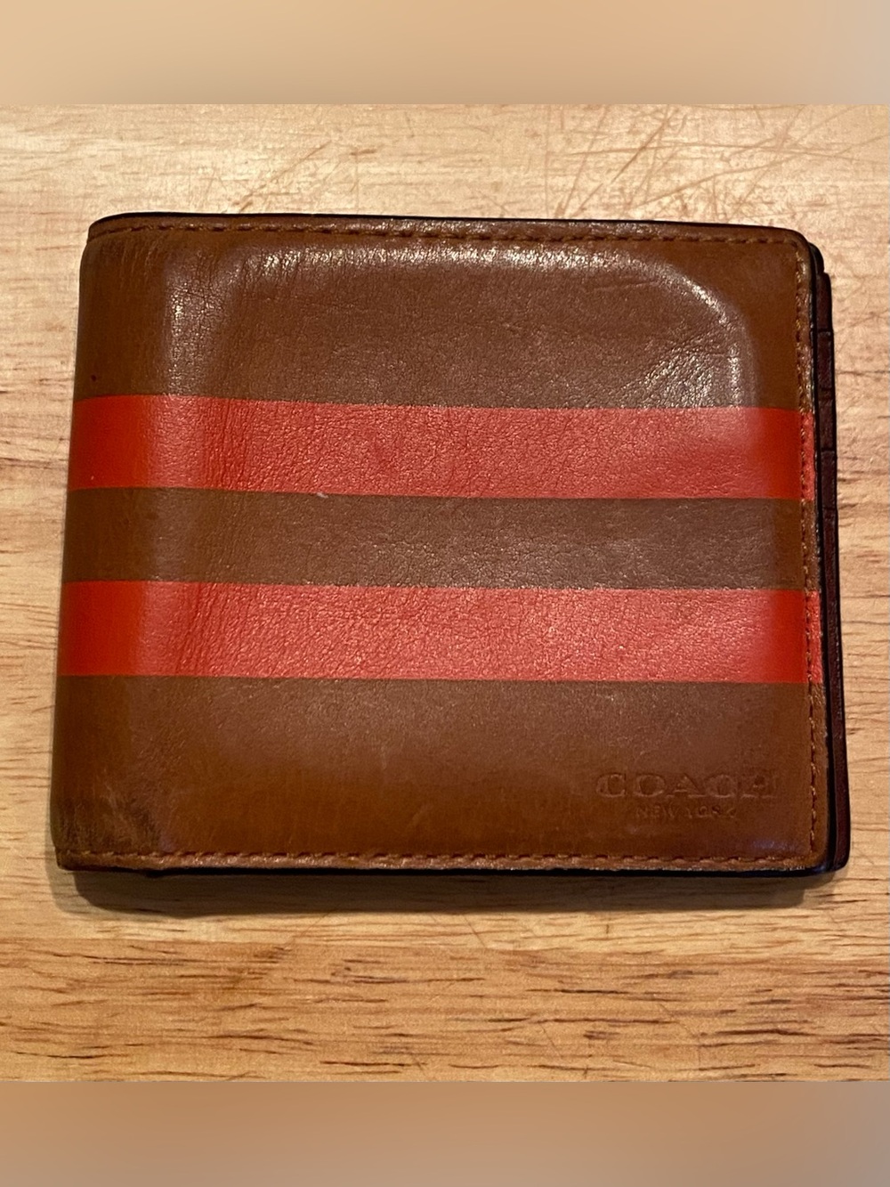 men's wallet featuring the "COACH NEW YORK" stamp and the Varsity Stripe.